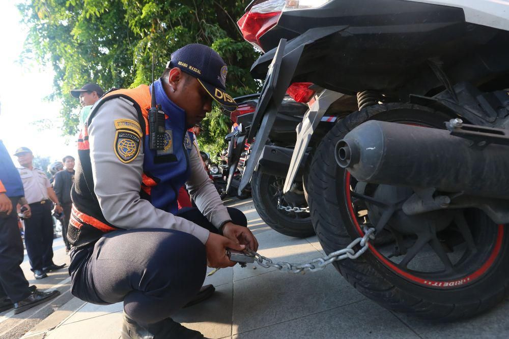 Dishub Surabaya saat melakukan penggembokan kendaraan yang parkir liar dan Depan Grand City Surabaya, Jumat (25/10/2024). (Dok. Dishub Kota Surabaya)