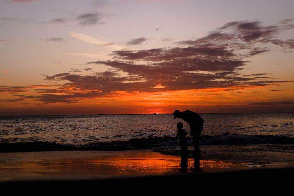 Menikmati sunset di Pantai Padang, seorang ayah mengajak anaknya menikmati sunset di Pantai Padang (Foto: IDN Times/Halbert Caniago)