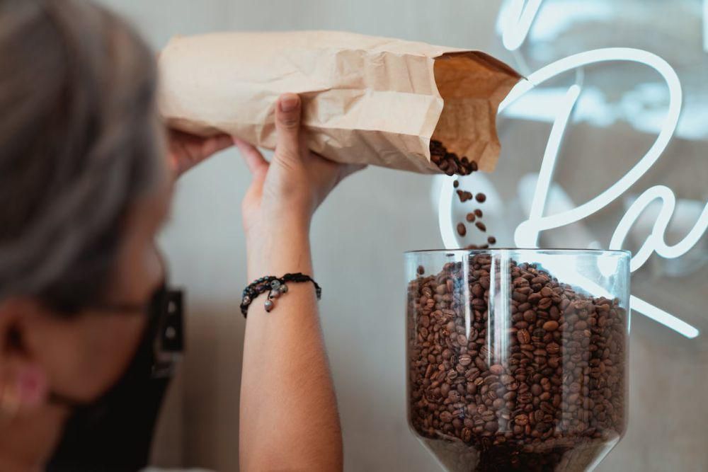 Potret orang menuang biji kopi