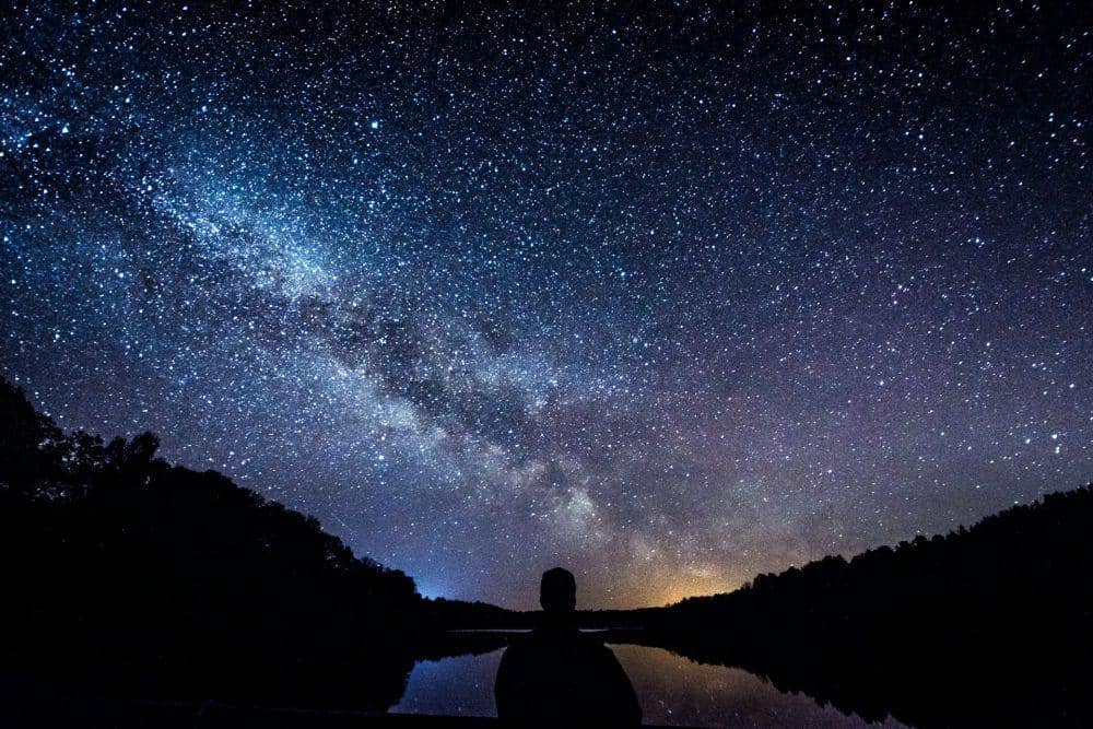ilustrasi seorang pria melihat langit di malam hari (unsplash.com/Mindaugas Vitkus)