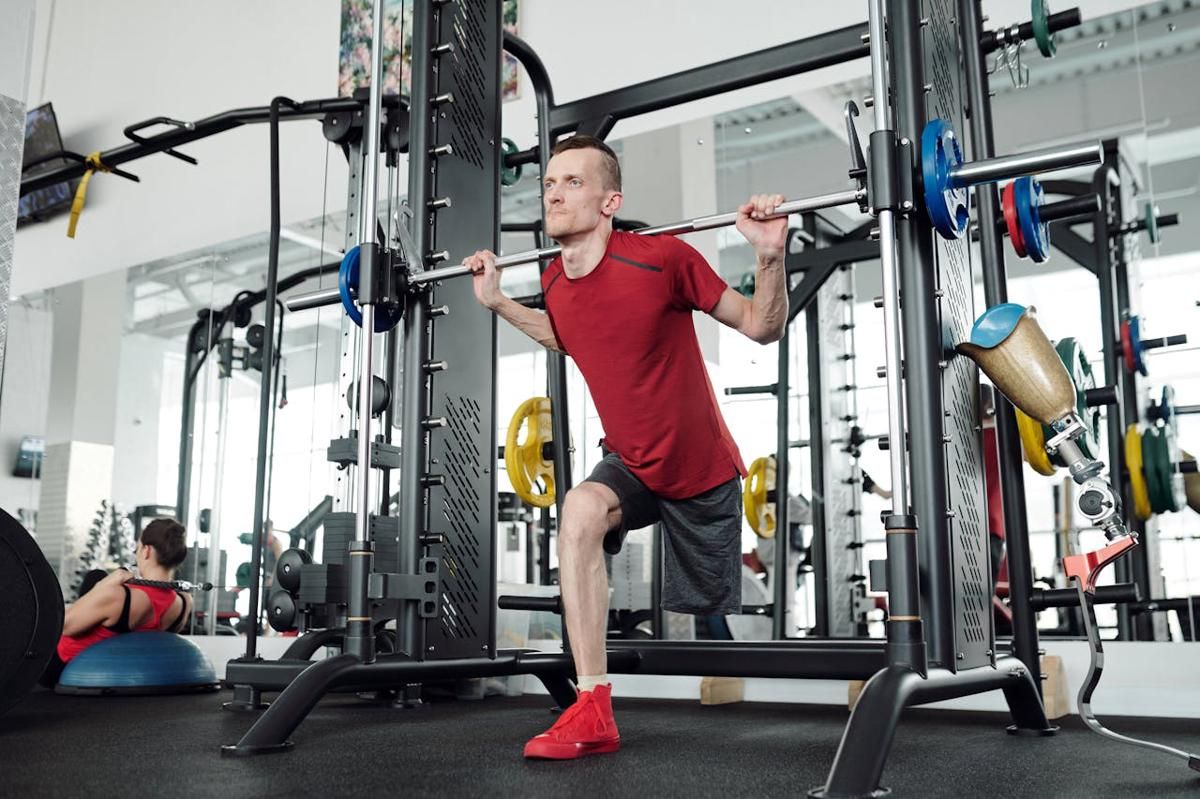Seorang laki-laki latihan beban dengan Smith machine.
