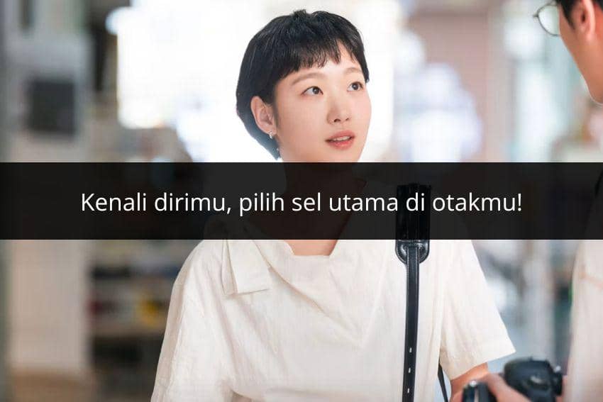 Seorang perempuan berambut pendek mengenakan pakaian putih sedang berbicara dengan seseorang di tempat umum dengan teks motivasi di layar.
