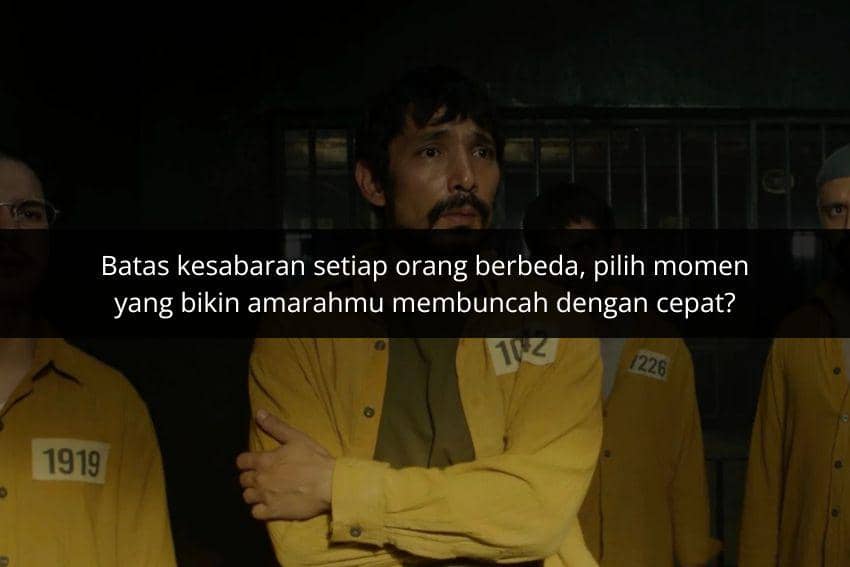 Seorang pria mengenakan seragam tahanan kuning berdiri dengan ekspresi serius di dalam ruangan penjara bersama beberapa tahanan lain.