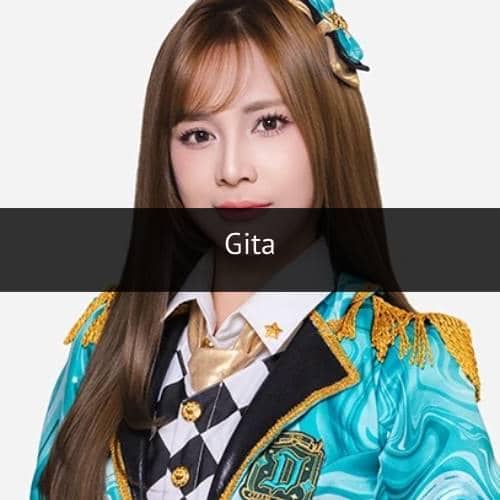 Seorang anggota grup idola mengenakan kostum panggung berwarna biru toska dengan hiasan emas dan pita di rambutnya.