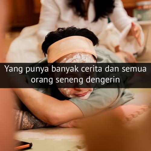 Seseorang berbaring santai dengan masker wajah dan handuk di kepala, sementara orang lain tampak di latar belakang.