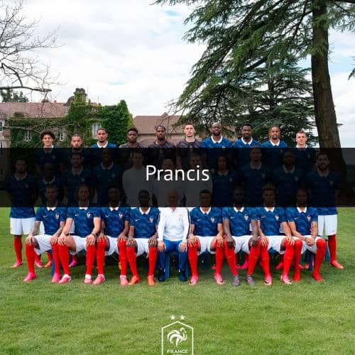 Tim nasional sepak bola Prancis berpose bersama di luar ruangan mengenakan seragam biru dengan celana putih dan kaus kaki merah.