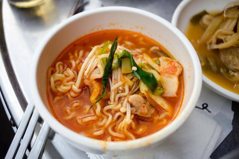 Tampilan close-up ramyeon pedas yang lezat dengan sayuran di dalam mangkuk.