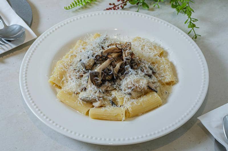 Sepiring pasta dengan jamur dan keju parmesan.