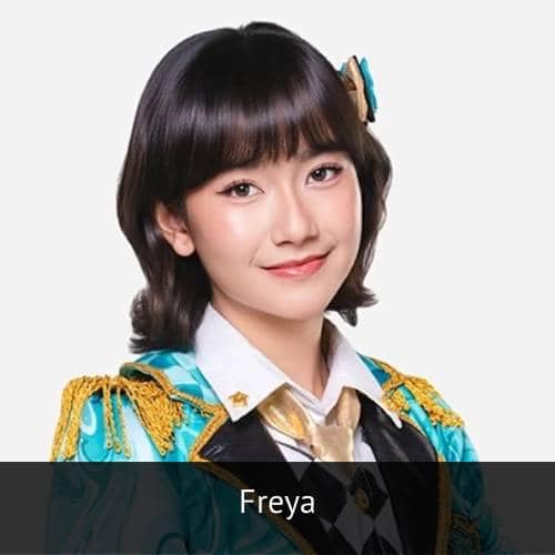 Seorang perempuan muda berambut pendek mengenakan kostum panggung berwarna biru dan emas dengan senyum ramah di wajahnya.
