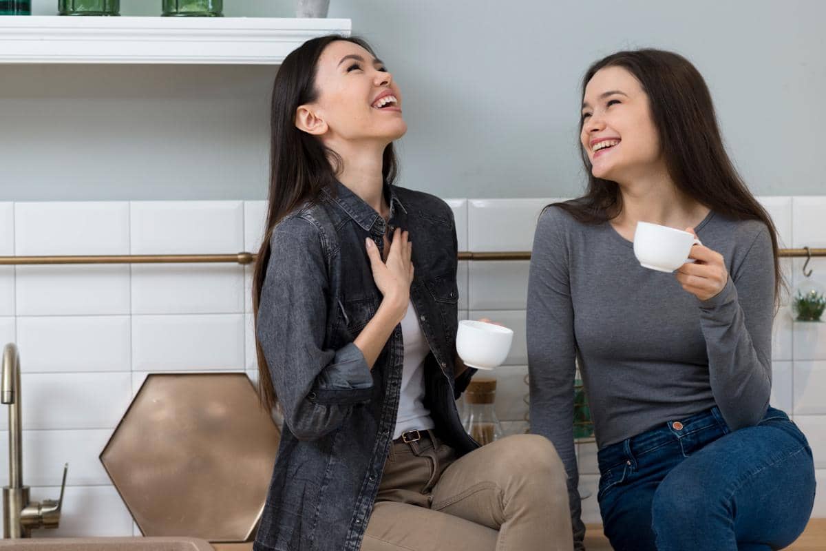 Wanita cantik tertawa sambil minum kopi